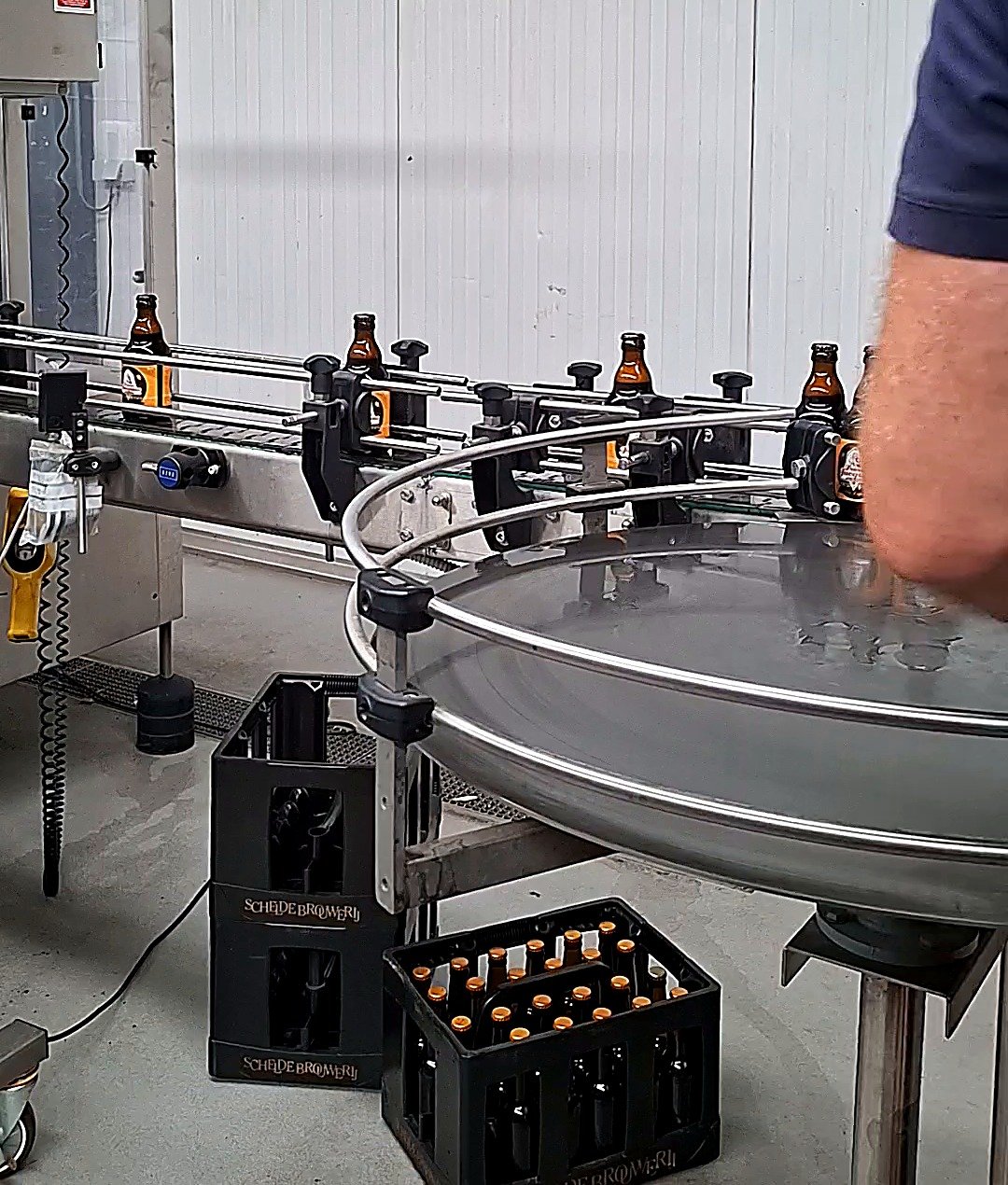 Bottles moving through the rotary bottling and capping line at the brewery